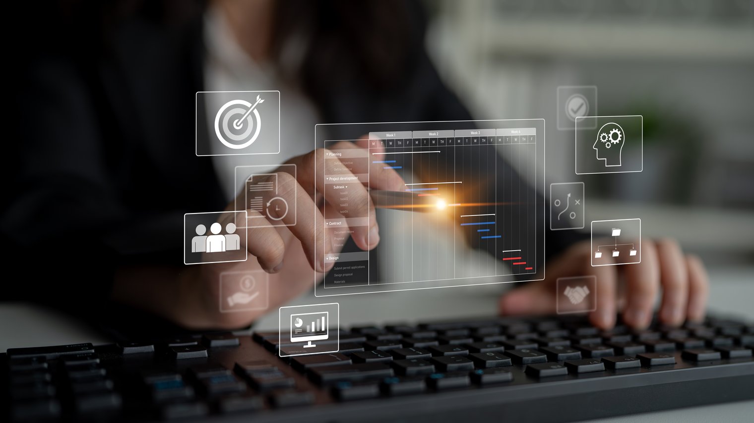 A imagem mostra uma pessoa usando um teclado e interagindo com uma interface digital projetada no ar, simbolizando o uso de tecnologia avançada em gestão de projetos. Elementos gráficos flutuantes representam ícones como alvo (metas), gráfico de Gantt (planejamento e cronograma), pessoas (equipe), engrenagens (processos), cérebro (inteligência ou estratégia) e monitor com gráficos (análise de desempenho). O ambiente é corporativo e moderno, transmitindo conceitos de transformação digital, produtividade e gestão inteligente baseada em dados.