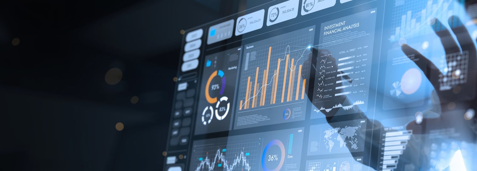 A imagem mostra um painel digital de análise de dados e indicadores de desempenho, exibindo gráficos de barras, linhas, gráficos de pizza e métricas financeiras em uma interface moderna. Em primeiro plano, a silhueta de um profissional interage com uma tela sensível ao toque, simbolizando o monitoramento de informações estratégicas, análise de desempenho e tomada de decisões baseada em dados em um ambiente corporativo.