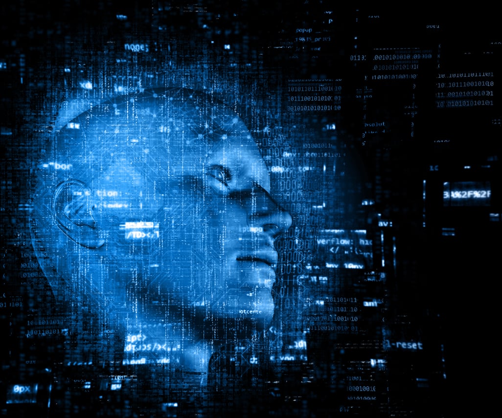 A imagem mostra uma renderização digital em tons de azul com um rosto humano tridimensional, semelhante a uma escultura ou modelo 3D, emergindo de um fundo repleto de códigos e elementos tecnológicos. Linhas de programação, números binários e símbolos de dados se sobrepõem à figura, criando um efeito de fusão entre o humano e o digital. A cena transmite uma atmosfera futurista e conceitual, representando temas como inteligência artificial, consciência digital ou a integração entre homem e tecnologia.